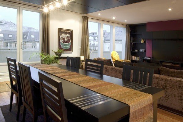 The dining table beside the salon windows.